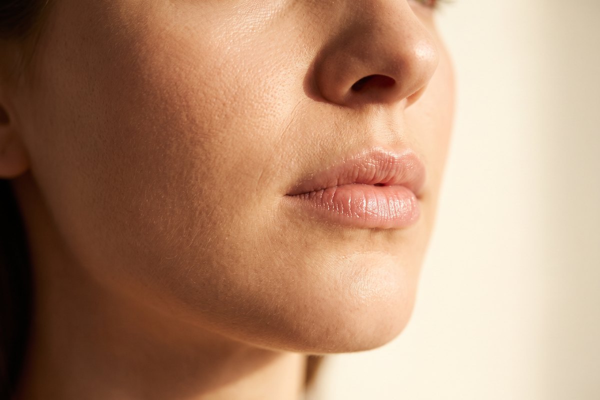 Beauty editorial close-up of naturally defined lips with a soft sheen in warm light, the natural look Hyalase restores when filler is dissolved at Facial Sculpting London