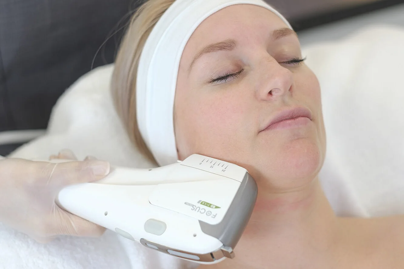 A patient relaxing during a Lynton Focus Dual lifting treatment as the handpiece is guided along her jawline